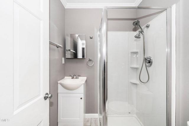 bathroom with crown molding, vanity, baseboards, and a stall shower