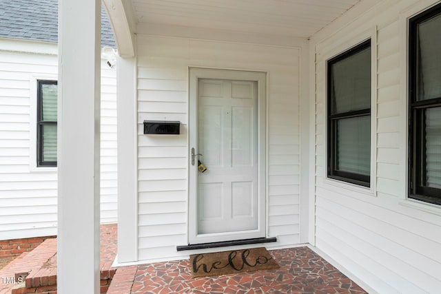 property entrance with a shingled roof