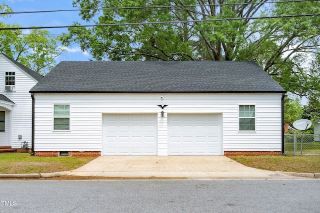 garage featuring fence and driveway