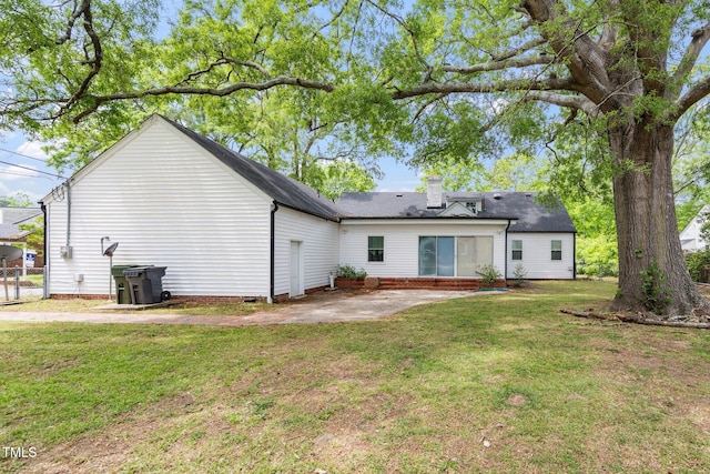 rear view of house featuring a chimney, a yard, a patio area, and crawl space