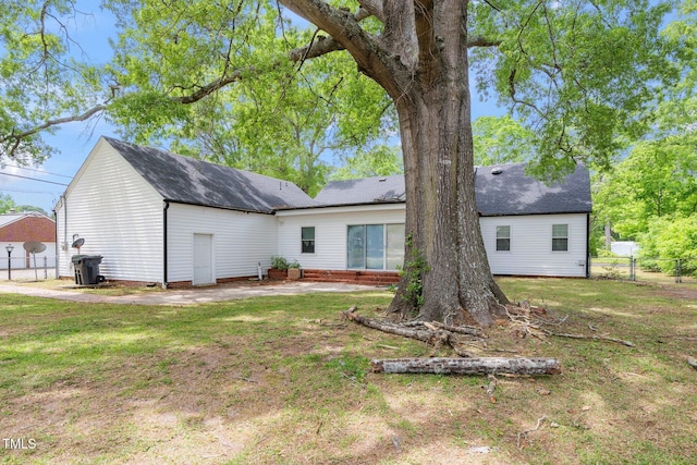 back of property with fence and a lawn