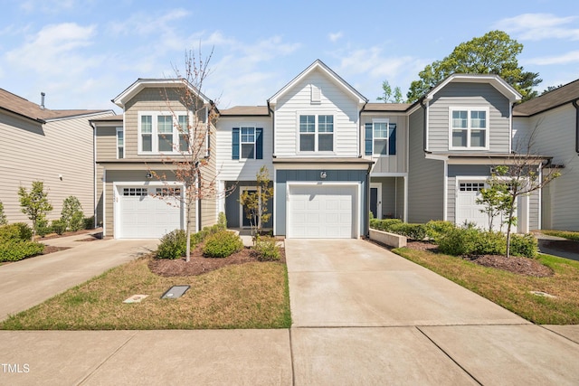 view of property featuring board and batten siding, an attached garage, and driveway