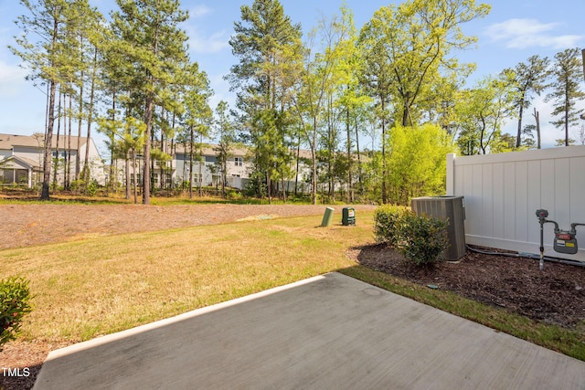 view of yard featuring fence and central AC