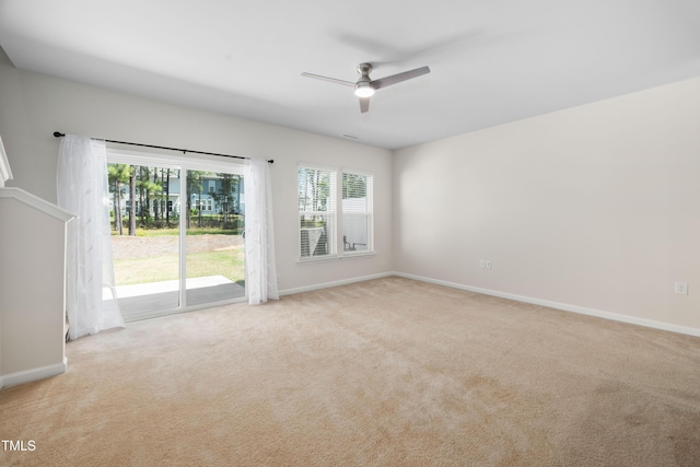 unfurnished room with ceiling fan, light colored carpet, and baseboards