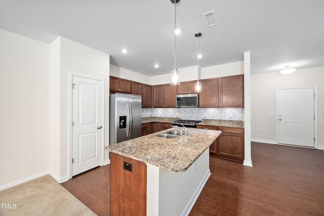 kitchen with visible vents, a sink, appliances with stainless steel finishes, dark wood-type flooring, and backsplash