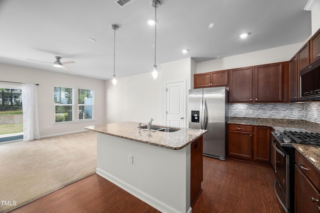 kitchen with appliances with stainless steel finishes, light stone countertops, dark wood finished floors, a sink, and ceiling fan