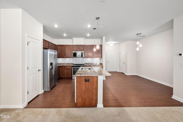 kitchen with tasteful backsplash, baseboards, dark carpet, an island with sink, and stainless steel appliances