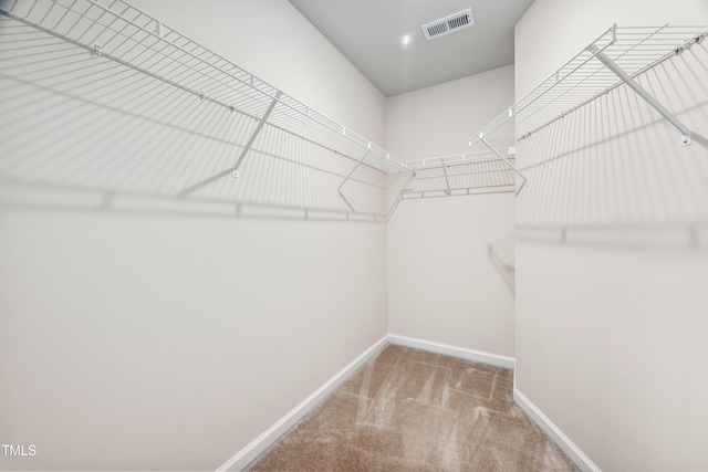 walk in closet with visible vents and carpet