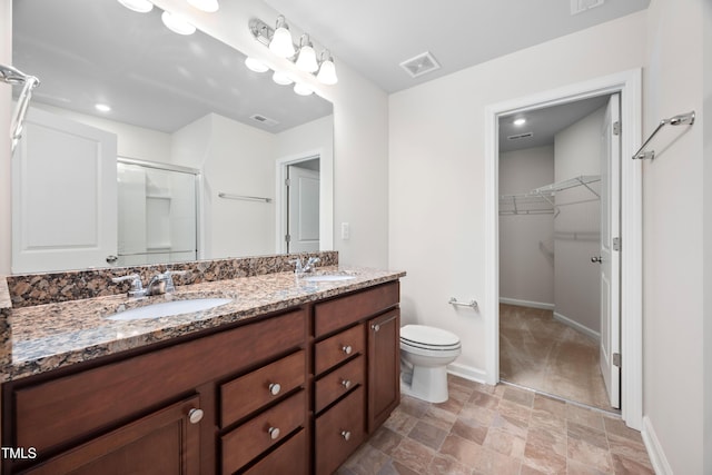 full bath featuring baseboards, a stall shower, a sink, and visible vents