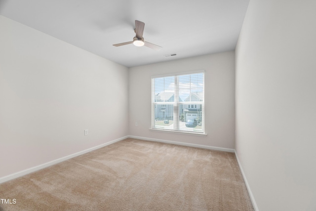 unfurnished room featuring visible vents, light colored carpet, baseboards, and ceiling fan
