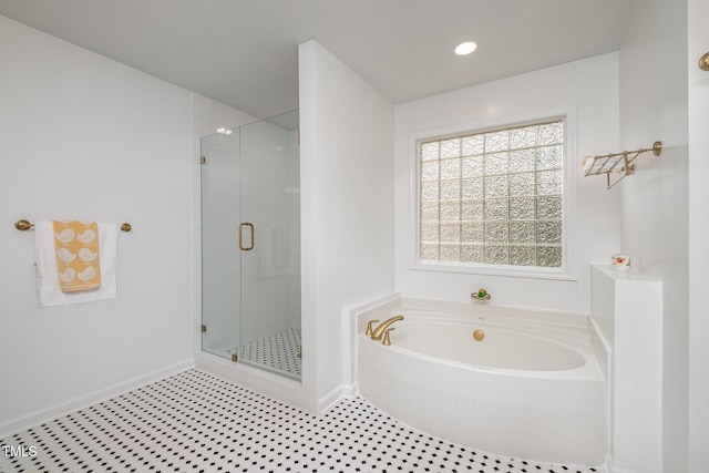 full bath with baseboards, a garden tub, and a stall shower