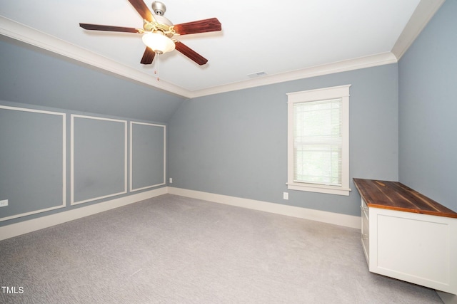 interior space featuring vaulted ceiling, visible vents, light colored carpet, and a ceiling fan