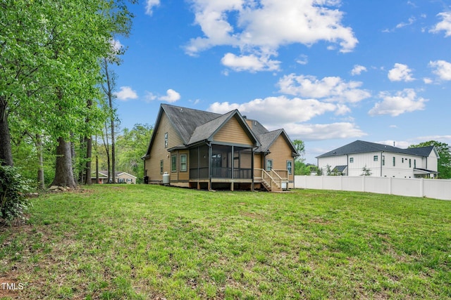 back of house with a sunroom, fence, and a lawn