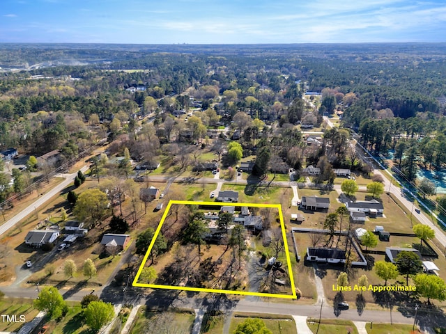 bird's eye view with a wooded view
