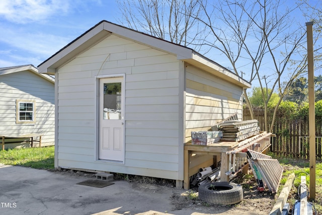 view of outdoor structure with fence and an outbuilding