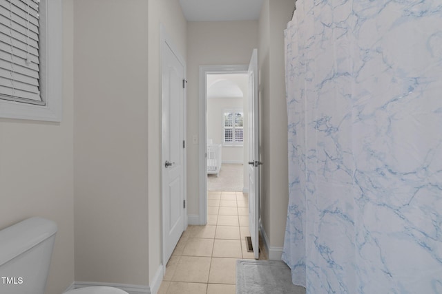 5928 Terrington Ln, Raleigh, NC 27606 - bathroom featuring a shower with shower curtain, tile patterned flooring, baseboards, and toilet
