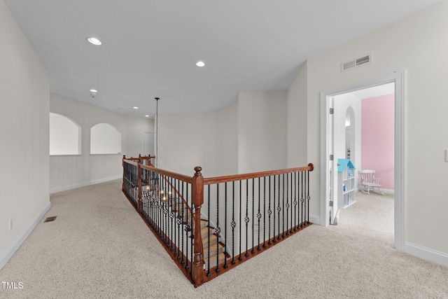 5928 Terrington Ln, Raleigh, NC 27606 - hall with arched walkways, visible vents, carpet, and an upstairs landing
