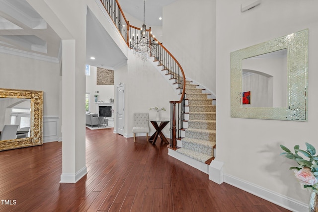 5928 Terrington Ln, Raleigh, NC 27606 - foyer entrance with baseboards, hardwood / wood-style flooring, a towering ceiling, stairs, and a glass covered fireplace