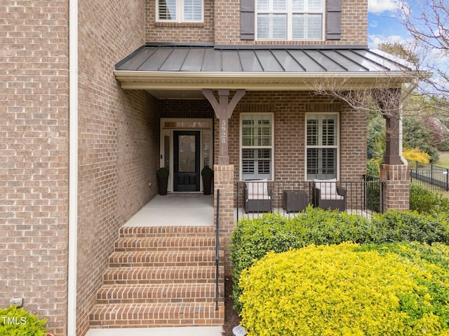 5928 Terrington Ln, Raleigh, NC 27606 - view of exterior entry with brick siding, a porch, metal roof, and a standing seam roof