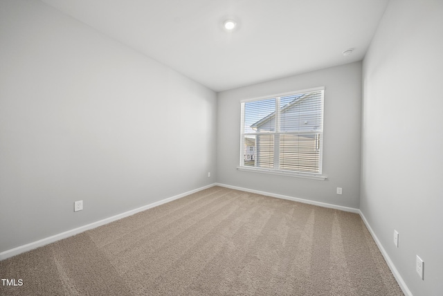 unfurnished room featuring carpet and baseboards