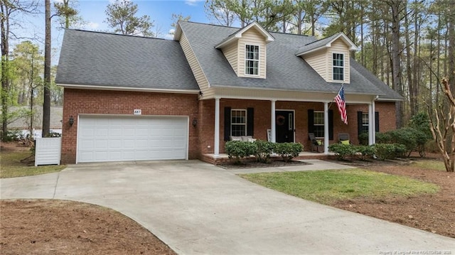 887 Thrush Dr, Vass, NC 28394 - cape cod house with roof with shingles, an attached garage, brick siding, a porch, and concrete driveway