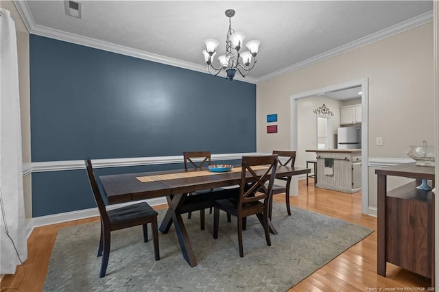 887 Thrush Dr, Vass, NC 28394 - dining room featuring visible vents, baseboards, light wood finished floors, a chandelier, and ornamental molding