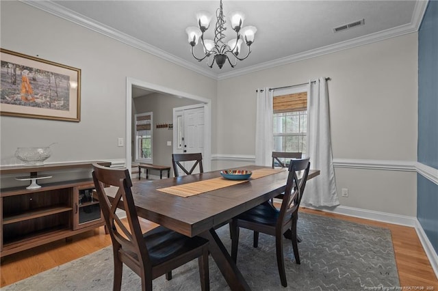 887 Thrush Dr, Vass, NC 28394 - dining space with crown molding, a chandelier, visible vents, and wood finished floors