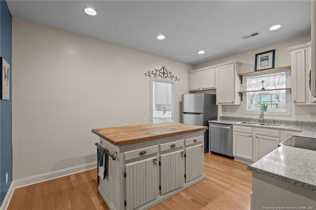 887 Thrush Dr, Vass, NC 28394 - kitchen featuring wooden counters, visible vents, appliances with stainless steel finishes, a sink, and washer and dryer