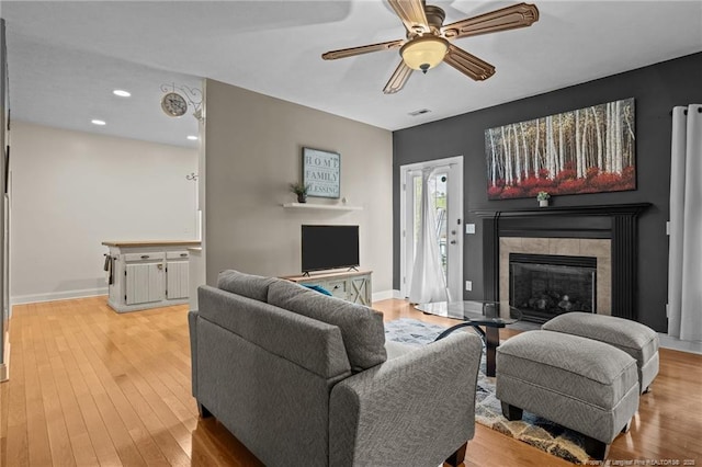 887 Thrush Dr, Vass, NC 28394 - living room with visible vents, wood finished floors, baseboards, a tile fireplace, and a ceiling fan