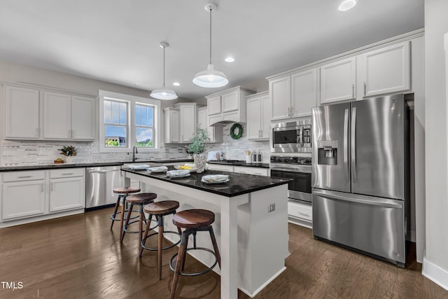 706 Fireball Ct, Knightdale, NC 27545 - kitchen with appliances with stainless steel finishes, dark countertops, white cabinetry, a sink, and recessed lighting