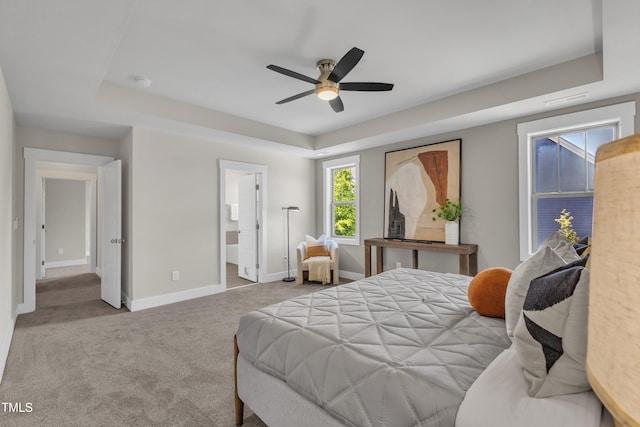 706 Fireball Ct, Knightdale, NC 27545 - carpeted bedroom with baseboards, a raised ceiling, ensuite bath, and ceiling fan