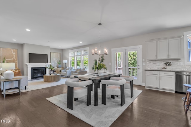 706 Fireball Ct, Knightdale, NC 27545 - dining area with dark wood finished floors, a chandelier, recessed lighting, and a glass covered fireplace