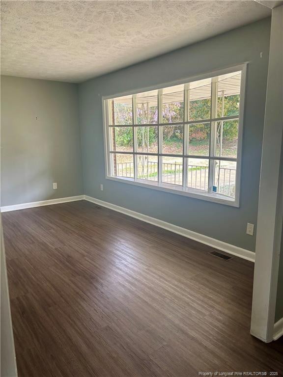 5704 Selkirk Pl, Fayetteville, NC 28304 - unfurnished room featuring a healthy amount of sunlight, baseboards, dark wood finished floors, and visible vents