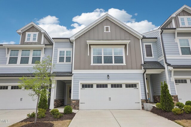 multi unit property with concrete driveway, stone siding, and board and batten siding