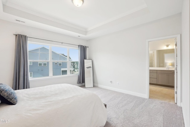 bedroom with visible vents, baseboards, a raised ceiling, a sink, and light colored carpet