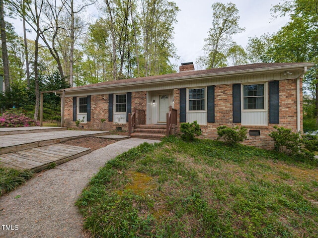 ranch-style home featuring crawl space, a chimney, and brick siding