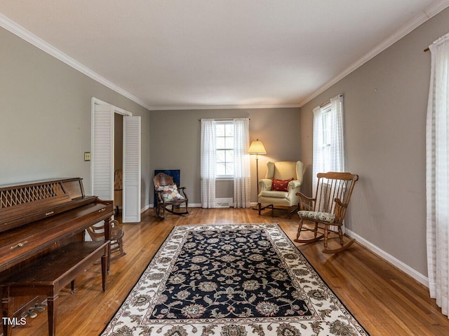sitting room with ornamental molding, baseboards, and wood finished floors