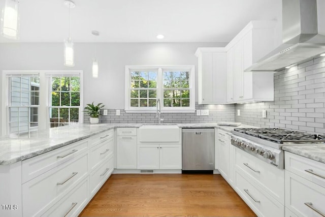 102 Cockleshell Ct, Cary, NC 27513 - kitchen with wall chimney exhaust hood, white cabinetry, a sink, stainless steel appliances, and backsplash