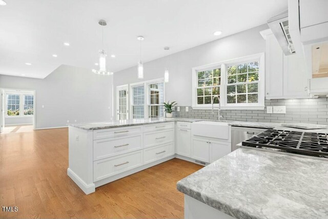 102 Cockleshell Ct, Cary, NC 27513 - kitchen with a sink, decorative backsplash, light wood-type flooring, and a peninsula
