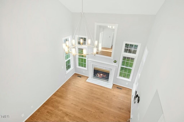 102 Cockleshell Ct, Cary, NC 27513 - unfurnished living room with wood finished floors, an inviting chandelier, visible vents, and a wealth of natural light