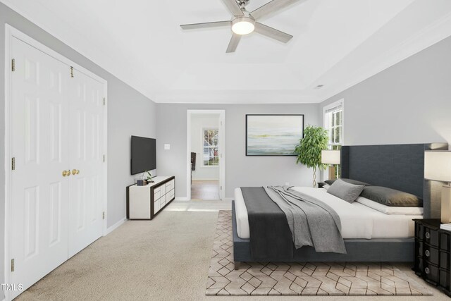 102 Cockleshell Ct, Cary, NC 27513 - bedroom with baseboards, a raised ceiling, light colored carpet, and a ceiling fan