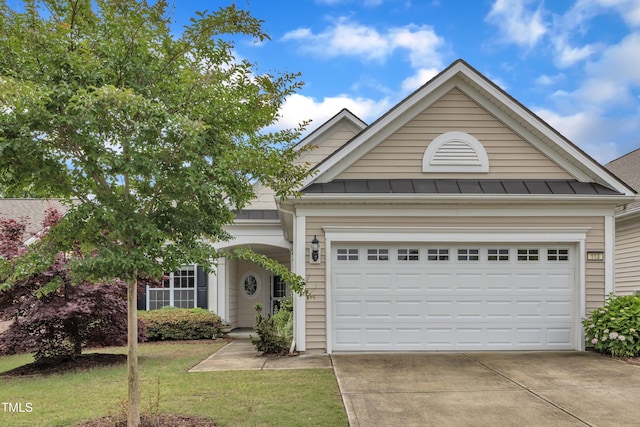 113 Dowington Ln, Cary, NC 27519 - view of front of property with driveway, a standing seam roof, an attached garage, a front lawn, and metal roof