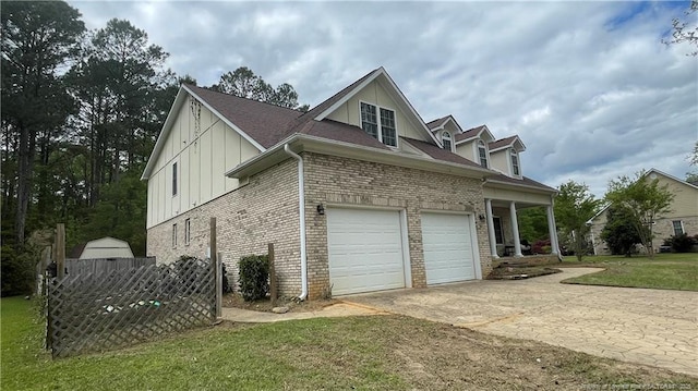 view of side of property featuring an attached garage, a lawn, board and batten siding, brick siding, and driveway