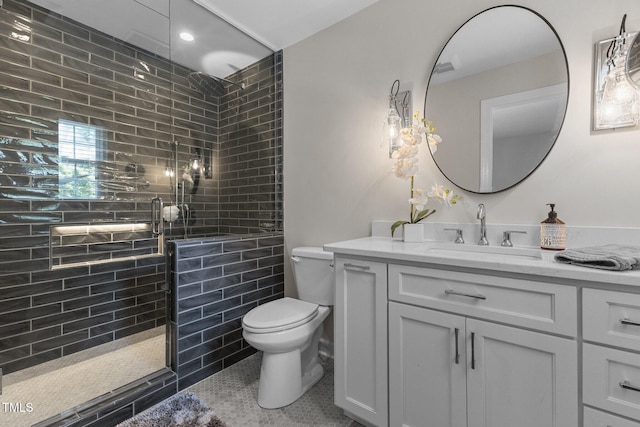 bathroom featuring toilet, a tile shower, vanity, and recessed lighting