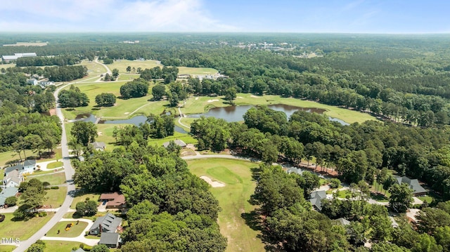 aerial view of property's location featuring a golf club, a nearby body of water, and a forest