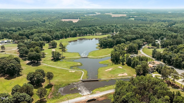 drone / aerial view of a nearby body of water, a forest, and a golf club