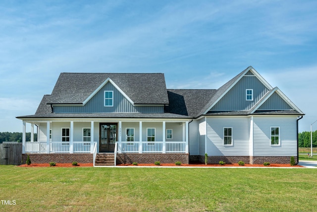 modern farmhouse featuring board and batten siding, covered porch, a front yard, and a shingled roof