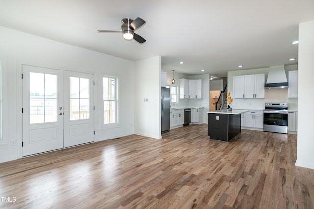 kitchen featuring appliances with stainless steel finishes, custom exhaust hood, light countertops, light wood-type flooring, and recessed lighting
