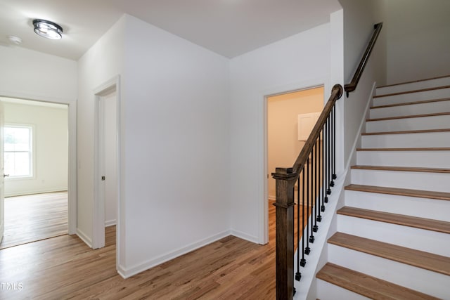 stairs with wood finished floors and baseboards