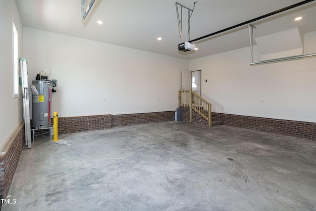 garage featuring electric water heater, a garage door opener, and recessed lighting